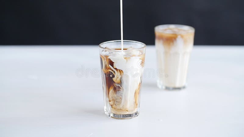 Conceito do café e dos cocktail O creme derramou no café com gelo