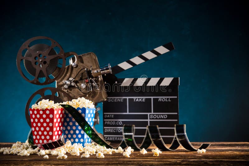 Conceito do cinema do carretel de filme do vintage com pipoca imagens de stock Conceito do cinema do carretel de filme do vintage com pipoca imagens de stock