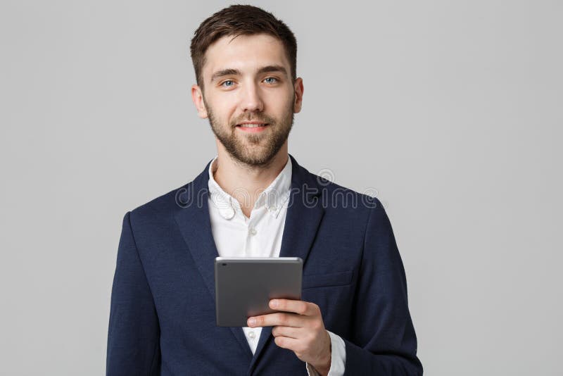 Conceito do negócio - homem de negócio considerável do retrato que joga a tabuleta digital com a cara segura de sorriso Fundo bra foto de stock Conceito do negócio - homem de negócio considerável do retrato que joga a tabuleta digital com a cara segura de sorriso Fundo bra foto de stock