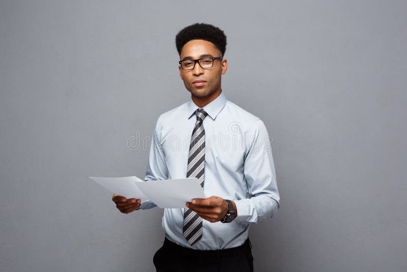 Conceito do negócio - homem de negócios afro-americano profissional novo considerável que guarda papéis do relatório fotos de stock Conceito do negócio - homem de negócios afro-americano profissional novo considerável que guarda papéis do relatório fotos de stock