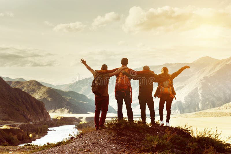Four happy friends are looking on mountains and having fun together. Space for text. Travel concept. Four happy friends are looking on mountains and having fun together. Space for text. Travel concept