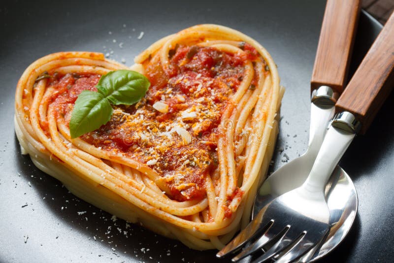 Conceito italiano do sumário da dieta de alimento do amor do coração da massa dos espaguetes no fundo preto imagens de stock royalty free Conceito italiano do sumário da dieta de alimento do amor do coração da massa dos espaguetes no fundo preto imagens de stock royalty free