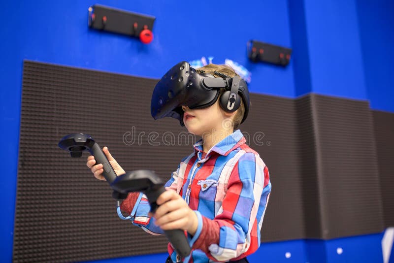 Conceito moderno da tecnologia, do jogo e dos povos - menino nos auriculares da realidade virtual ou nos vidros 3d que jogam o vi imagens de stock Conceito moderno da tecnologia, do jogo e dos povos - menino nos auriculares da realidade virtual ou nos vidros 3d que jogam o vi imagens de stock