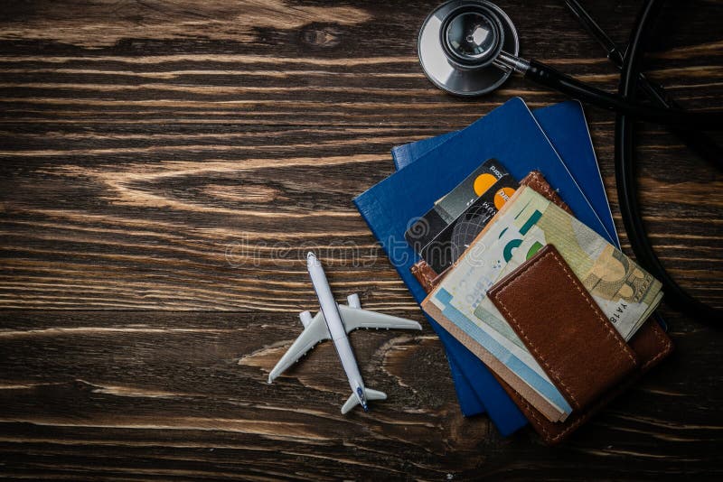 Conceito médico do turismo - passaportes, estetoscópio, avião, dinheiro