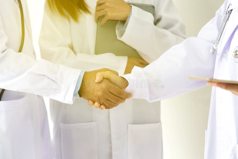 Conceito médico e dos cuidados médicos Aperto de mão médico novo dos povos no hospital Doutores da equipe que trabalham no escrit imagens de stock Conceito médico e dos cuidados médicos Aperto de mão médico novo dos povos no hospital Doutores da equipe que trabalham no escrit imagens de stock