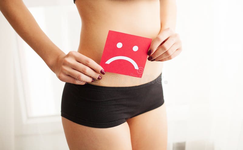 Conceito Vaginal ou urinário da infecção e dos problemas A jovem mulher guarda o papel com sorriso triste acima do gancho fotografia de stock Conceito Vaginal ou urinário da infecção e dos problemas A jovem mulher guarda o papel com sorriso triste acima do gancho fotografia de stock