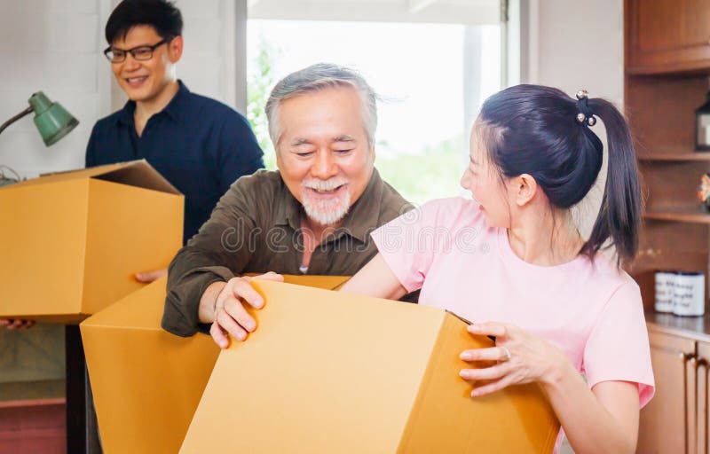 Moving day concepts, Asian family carrying boxes into new home, Happiness middle aged daughter son and senior father in new house. Moving day concepts, Asian family carrying boxes into new home, Happiness middle aged daughter son and senior father in new house.