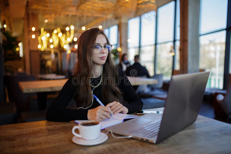 Atractiva mujer joven con largo cabello trenzado de moda mirando a través  de los listones de madera sobre un restaurante Fotografía de stock - Alamy