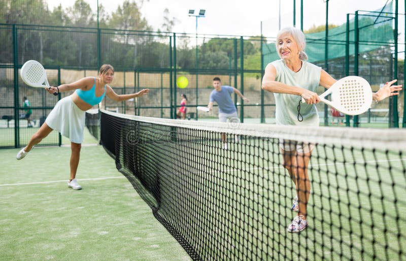 Aged Female Paddle Tennis Player Performing Backhand on Outdoor Court ...