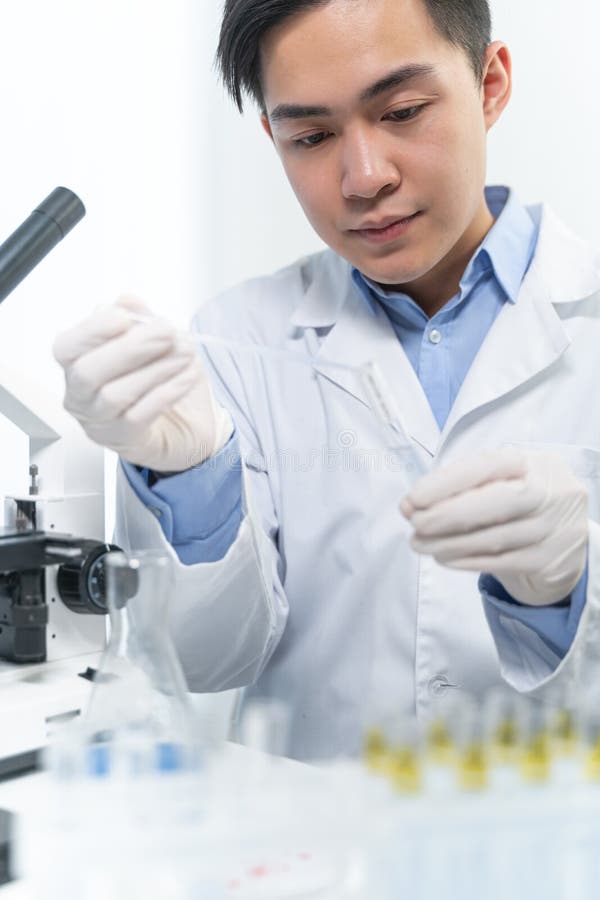 Concentrated Brunette Male Person Looking At Test Tube Stock Photo