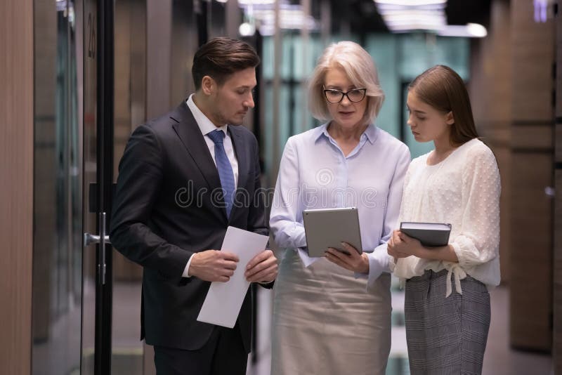 Concentrated middle aged female leader showing project results to colleagues.