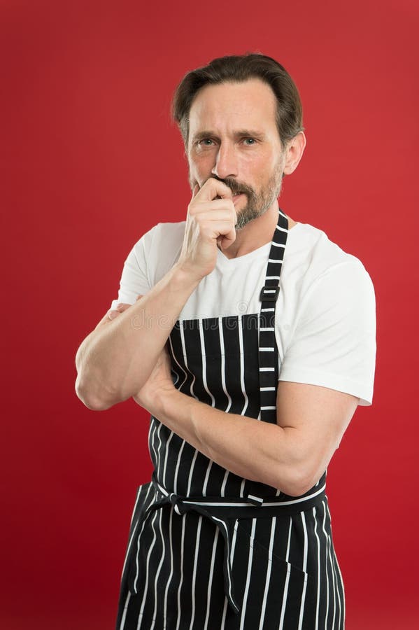 Concentrated On The Task Doing Household Bearded Mature Man In Striped Apron Senior Cook 