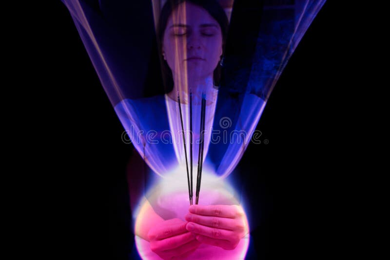 A concentrated woman keeps a pink burning ball. Quantum theory of man, consciousness and physics.