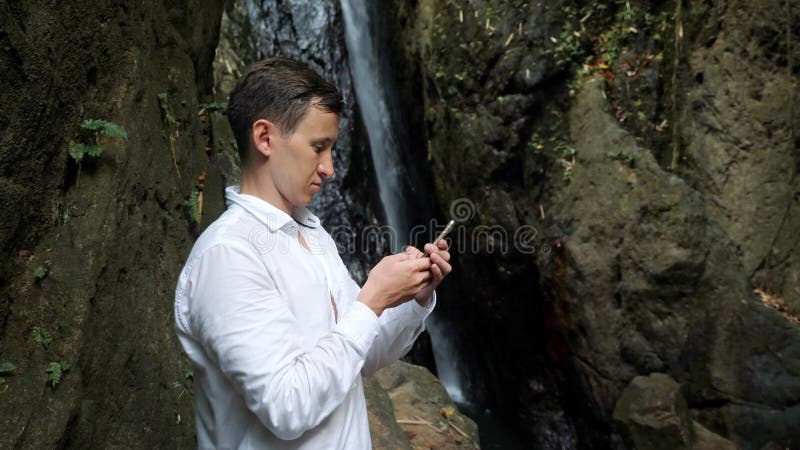 Young man holds smartphone in hand taps on screen and chats