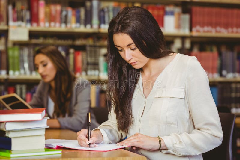 Concentrating pretty brunette student writing in notepad royalty free stock image Concentrating pretty brunette student writing in notepad royalty free stock image