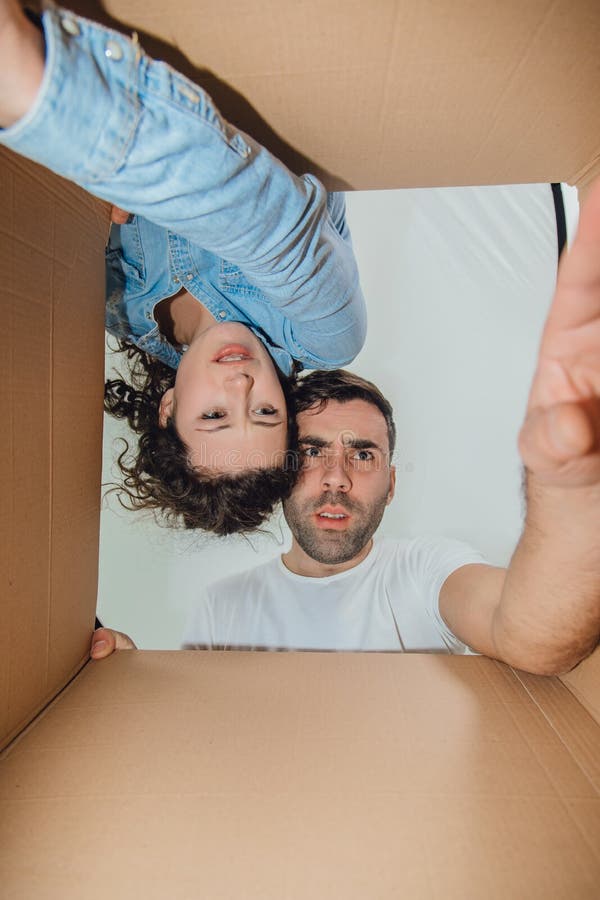 Curious Wife And Husband Unpacking Reaching Things From Carboard Box