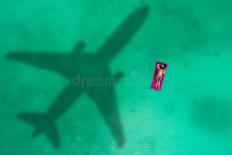 Concept of airplane travel to exotic destination with shadow of commercial airplane flying above beautiful tropical beach. Beach stock images Concept of airplane travel to exotic destination with shadow of commercial airplane flying above beautiful tropical beach. Beach stock images