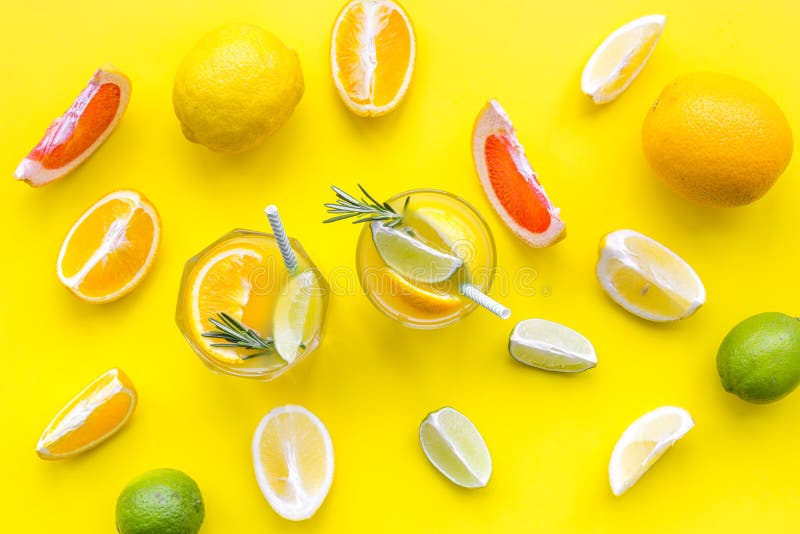 Concept of alcoholic cocktail with fruits. Glass with beverage near oranges, grapefruit, lime and rosemary on yellow. Background top view royalty free stock images Concept of alcoholic cocktail with fruits. Glass with beverage near oranges, grapefruit, lime and rosemary on yellow. Background top view royalty free stock images