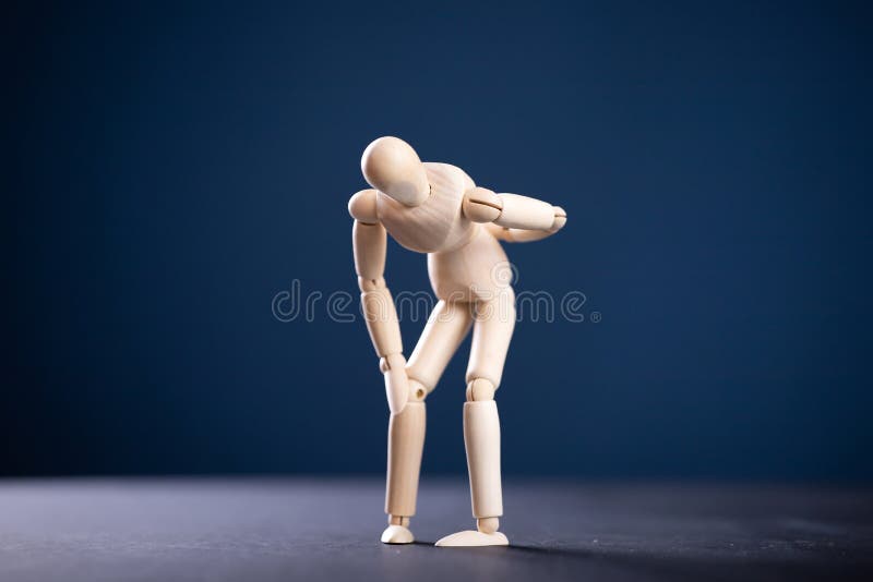 Concept of back pain. A wooden figure depicts a pain in the back