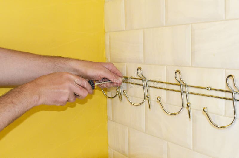 Concept of Bathroom Remodeling. Installation of Hanger, Towel Holder