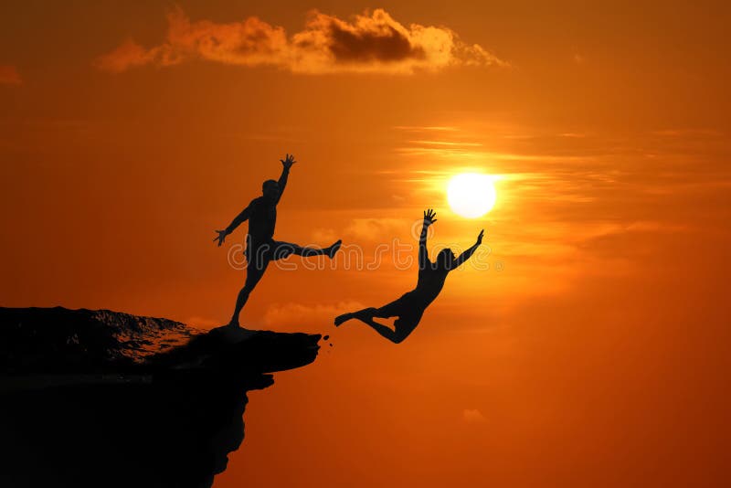 The concept of betrayal and the help of friends, Silhouette of Men are jumped between high cliff at a red sky sunset