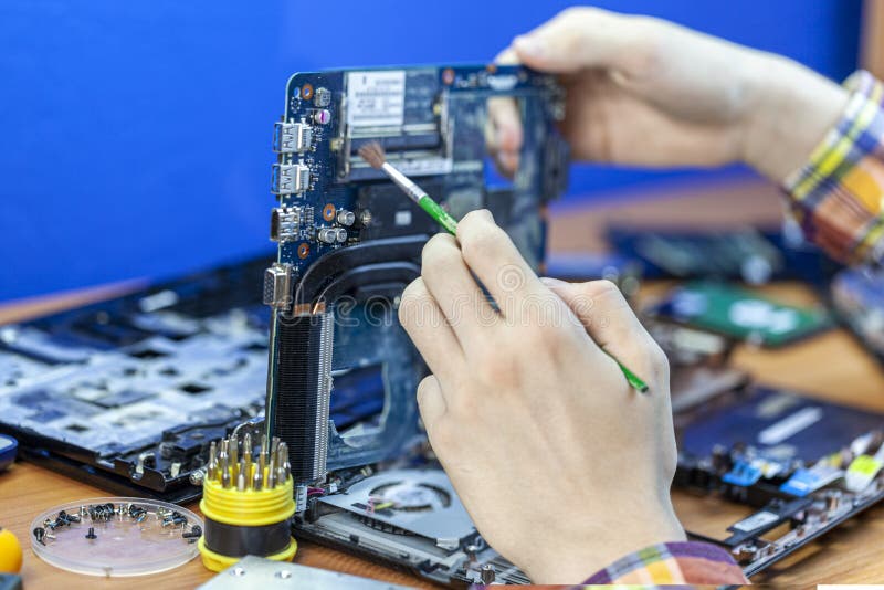 The concept of computer hardware, mobile phone, electronic, repairing, upgrade and technology, vacuum cleaning of the cooler from stock image