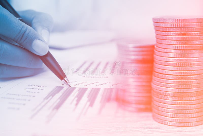 Concept of Currency Trading. Stack of Coins and a Hand Holding is Examining a Technical Chart of