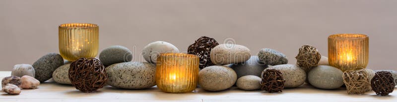 Concept of beauty, peace, spirituality, mindfulness or alternative medicine with mineral pebbles and candles, panoramic still life. Concept of beauty, peace, spirituality, mindfulness or alternative medicine with mineral pebbles and candles, panoramic still life