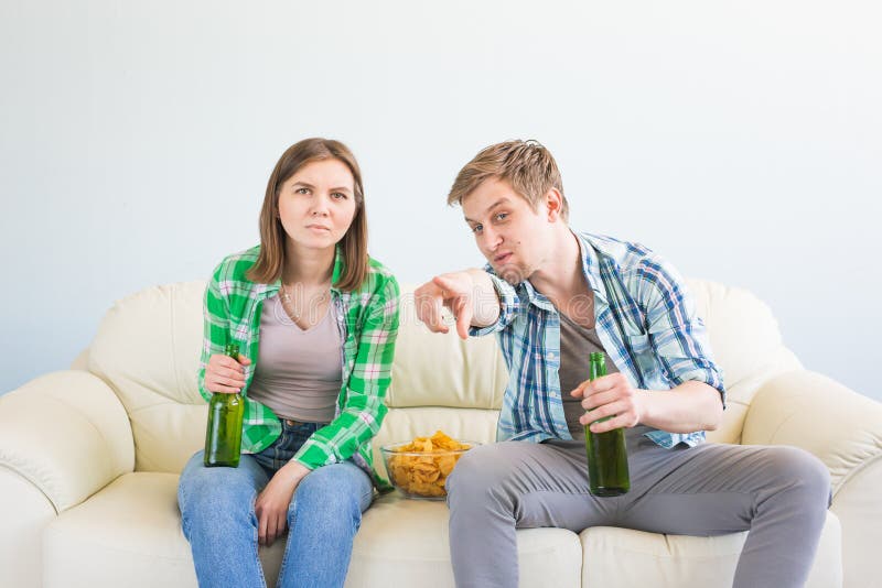 Concept de coupe du monde du football - couple des amis s'asseyant dans le jeu de observation de sport de sofa à la TV photos libres de droits Concept de coupe du monde du football - couple des amis s'asseyant dans le jeu de observation de sport de sofa à la TV photos libres de droits