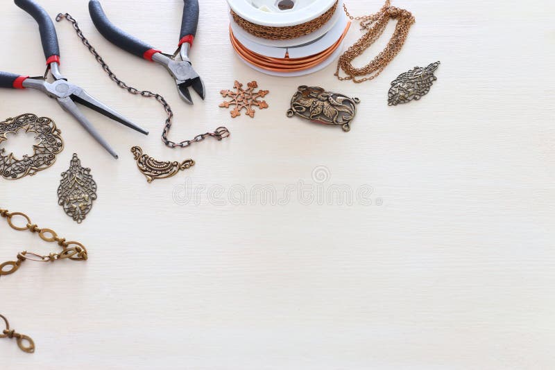 Concept de fabricare a bijuteriilor cu caractere filigranate cu lanț și instrumente pe fond alb din lemn royalty free stock photos