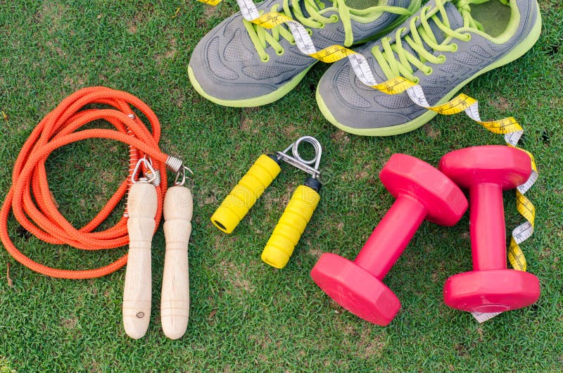 Concept de forme physique avec l'équipement d'exercice sur le backgroun d'herbe verte photographie stock Concept de forme physique avec l'équipement d'exercice sur le backgroun d'herbe verte photographie stock