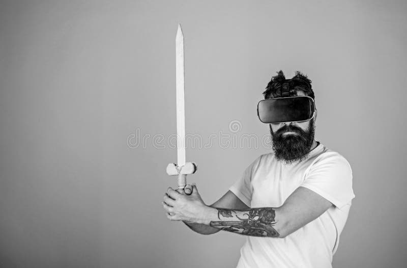 Concept de Gamer Homme avec la barbe en verres de VR, fond bleu-clair Le hippie sur le visage sérieux apprécient le jeu de jeu da image stock Concept de Gamer Homme avec la barbe en verres de VR, fond bleu-clair Le hippie sur le visage sérieux apprécient le jeu de jeu da image stock
