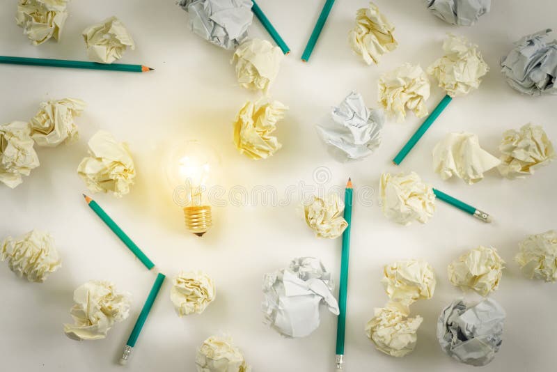 Concept de idei noi. bile de hârtie pentru bulbi strălucitoare, creioane colorate pe fond alb stock photos