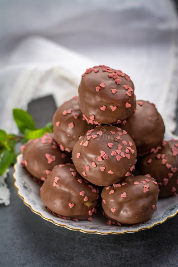 Concept de jour du ` s de Valentine, profiteroles de chocolat avec les coeurs roses images stock Concept de jour du ` s de Valentine, profiteroles de chocolat avec les coeurs roses images stock