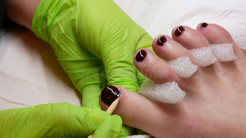 concept de la beaut? 4K P?dicurie dans les gants verts au salon Vernis ? ongles et fausses pierres marron Beau et riches