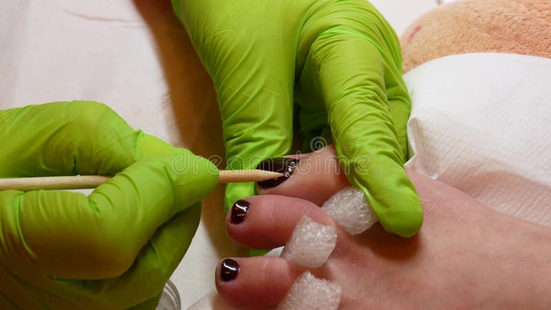 concept de la beaut? 4K P?dicurie dans les gants verts au salon Vernis ? ongles et fausses pierres marron Beau et riches