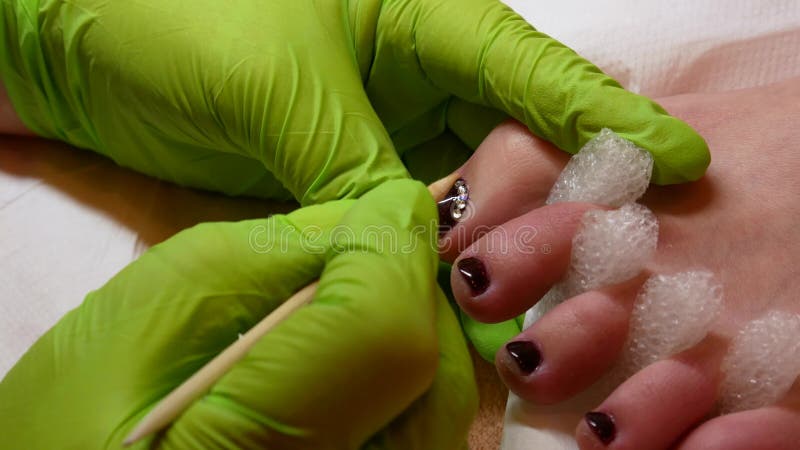 concept de la beaut? 4K P?dicurie dans les gants verts au salon Vernis ? ongles et fausses pierres marron Beau et riches