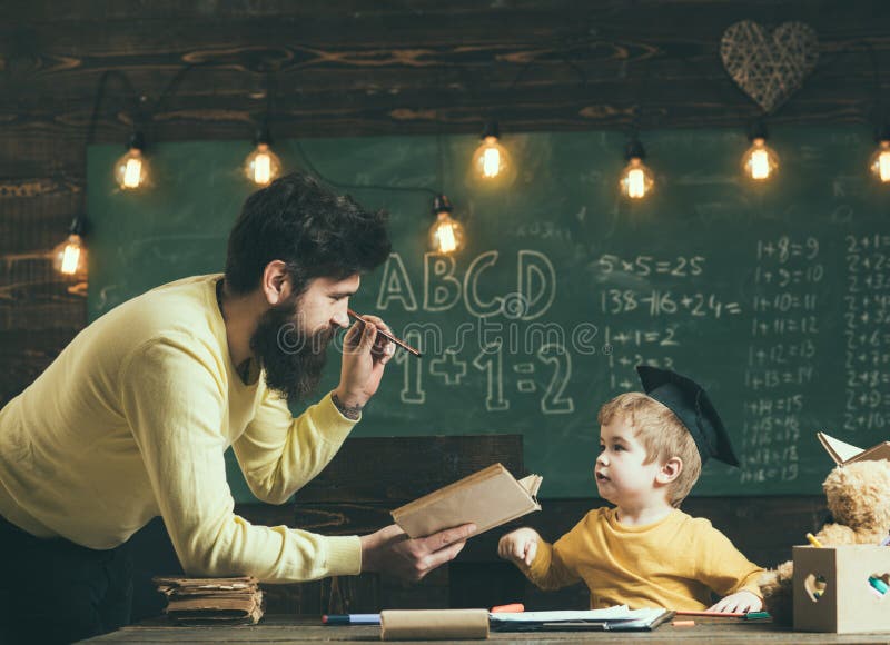 Concept de la connaissance Le professeur d'homme a lu le livre au petit garçon à l'école, la connaissance L'enfant obtiennent la image stock Concept de la connaissance Le professeur d'homme a lu le livre au petit garçon à l'école, la connaissance L'enfant obtiennent la image stock