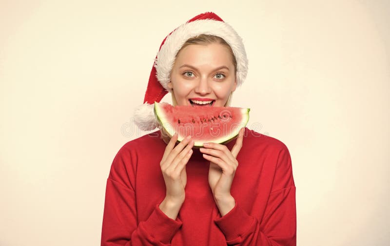 Concept de noël tropical. destinations d'été de noël. noël fille manger pastèque. femme santa chapeau tenir tranche photo libre de droits