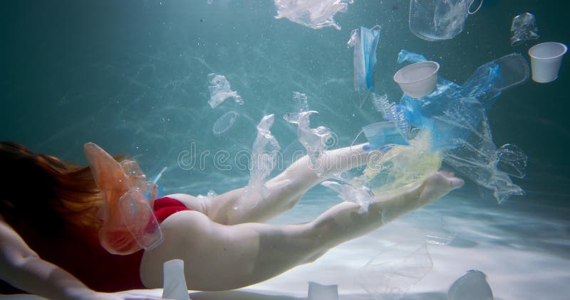 Concept de pollution plastique. jeunes femmes touriste nage à l'aide de déchets d'emballages à usage unique sous l'eau ralenti. clips vidéos