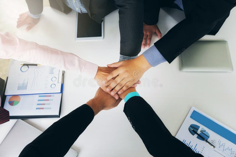 Concept de travail d'équipe : vue du haut des mains de l'équipe d'affaires montrant l'unité en mettant les mains ensemble.