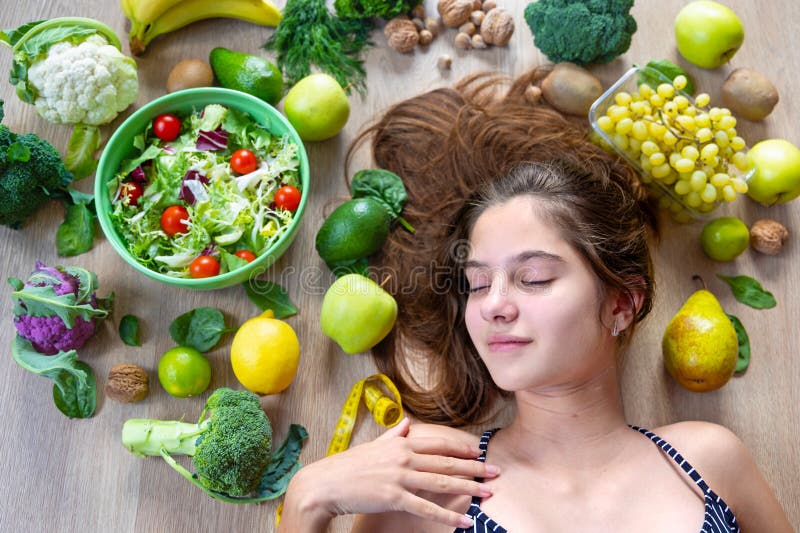 Concept de vie saine avec femme et produits frais. jeune femme relaxant entouré de fruits frais légumes et photographie stock libre de droits