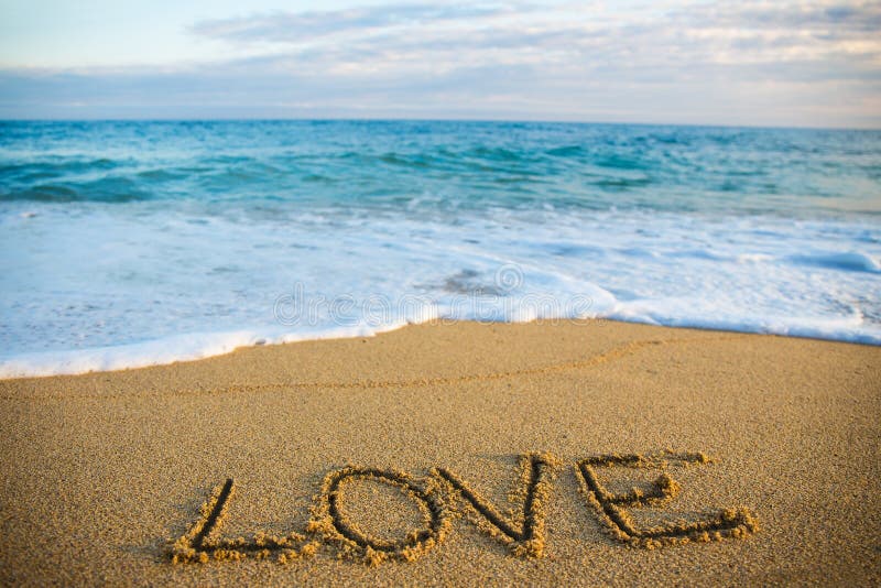 Travel concept - word love written in golden sand on the beach. Travel concept - word love written in golden sand on the beach