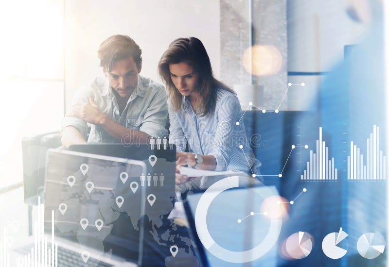 Concept of digital diagram,graph interfaces,virtual screen,connections icon.Two young coworkers working on computer at sunny office.Woman pointing on notebook screen. Blurred background