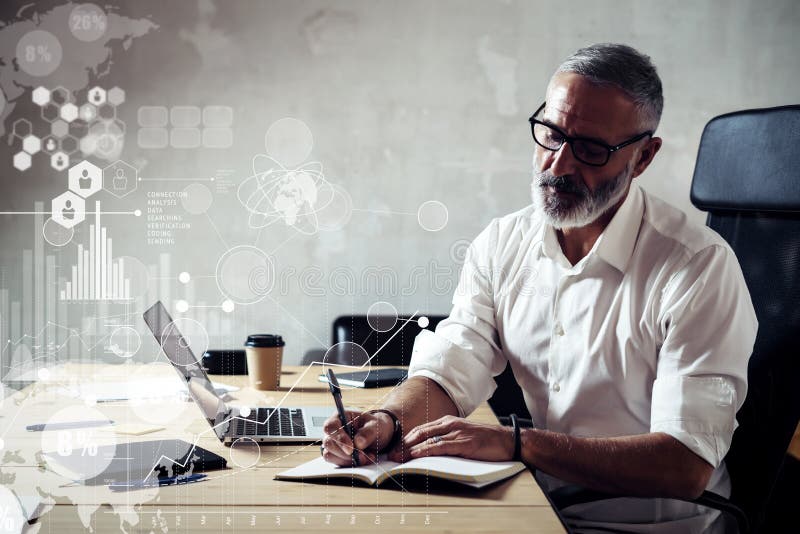 Concept of digital screen with global virtual icon,diagram, graph interfaces.Adult successful businessman wearing a classic glasses and working at the wood table in modern loft studio.Horizontal