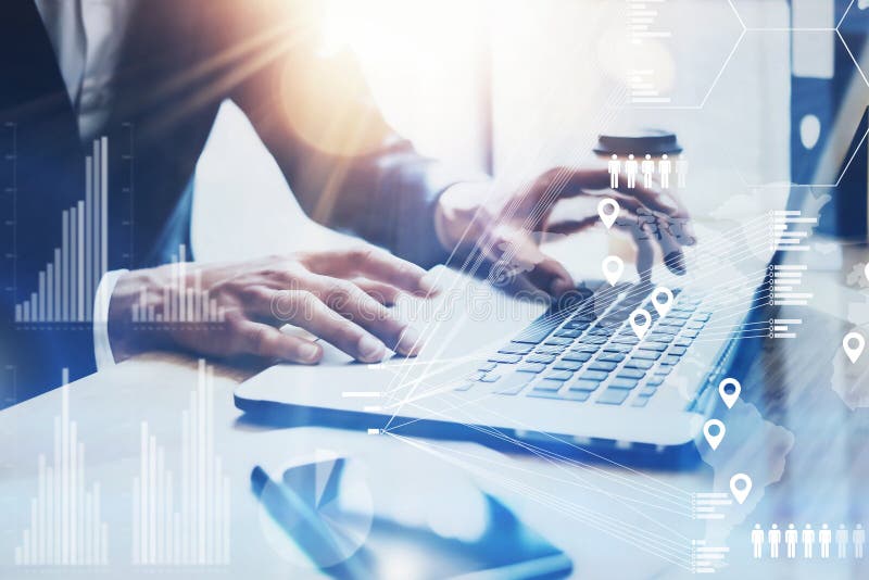 Concept of digital screen,virtual connection icon,diagram,graph interfaces.Businessman working at sunny office on laptop while sitting at the wooden table.Blurred background.Flares