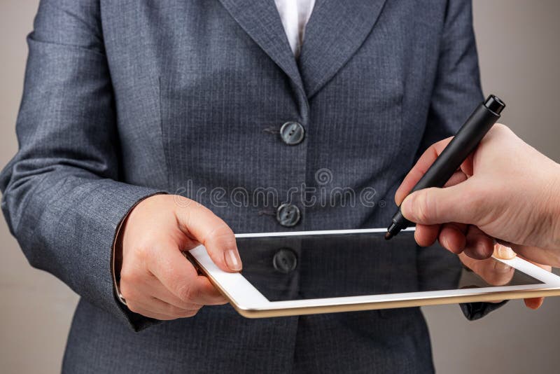 Digital signature concept, female hands, are holding a tablet, male hand is painting, selective focus, shallow depth of field. Digital signature concept, female hands, are holding a tablet, male hand is painting, selective focus, shallow depth of field.
