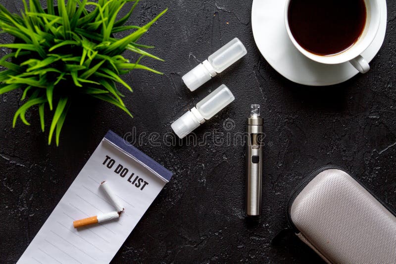 Concept of electronic cigarette on dark background top view