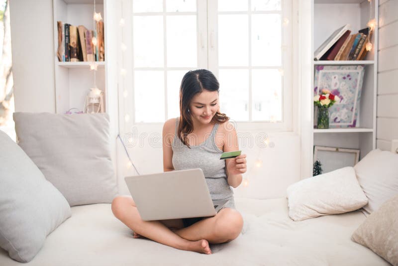 Concept en ligne d'achats Jeune femme asiatique tenant la carte de crédit a photographie stock libre de droits Concept en ligne d'achats Jeune femme asiatique tenant la carte de crédit a photographie stock libre de droits