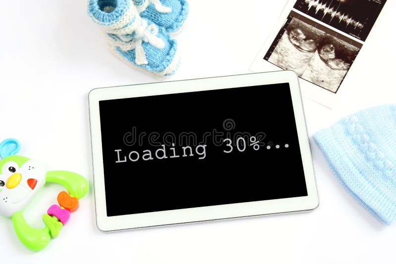 Concept of extending family and expecting for baby: screen tablet with inscription loading 30 percent, ultrasound scan of baby, cl stock photography